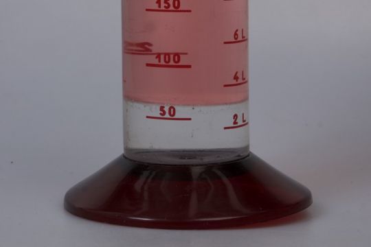 L'eau (transparente) plus lourde que le gasoil (rose) se dépose au fond du réservoir.