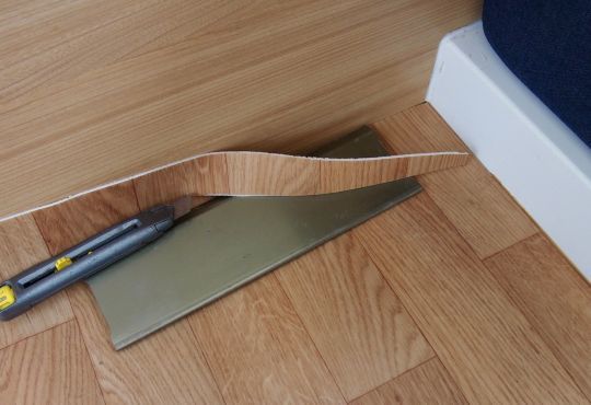 Une spatule métallique large sert de guide pour l'ajustage