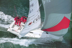 A Figaro 1 sailing at full speed under spinnaker in the 90s