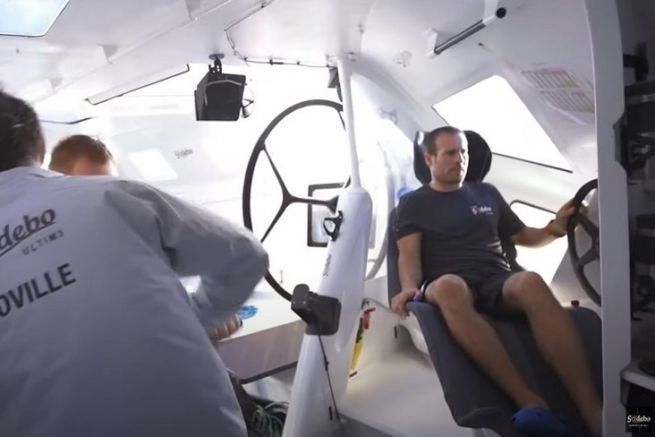 What's the partner doing sitting in the bucket seat with the steering wheel?